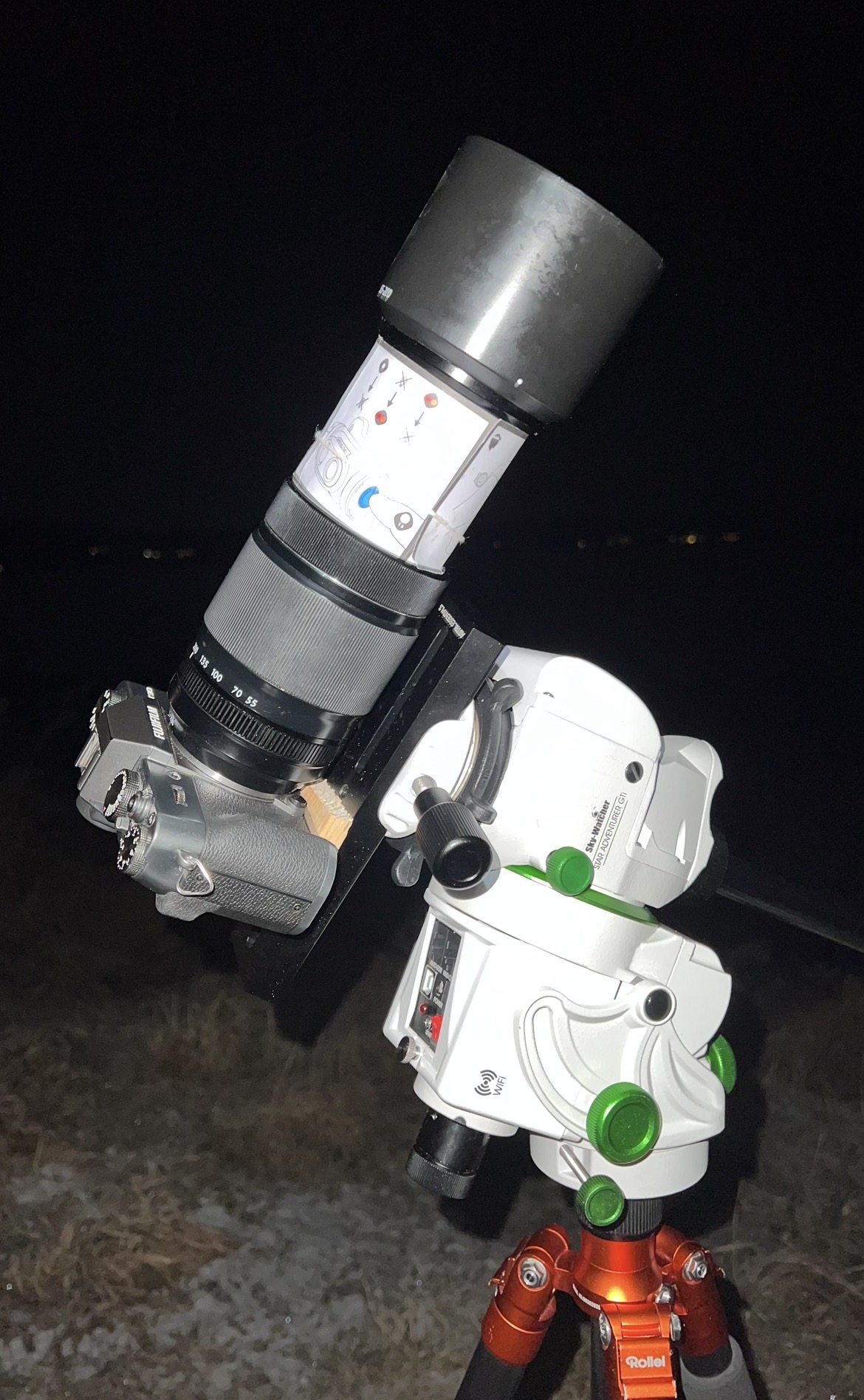 My camera mounted on a star tracker and tripod for astrophotography, with a paper ring on the zoom lens to stop zoom creep from frost.